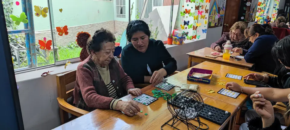 Una persona mayor participa en una actividad acompañada.