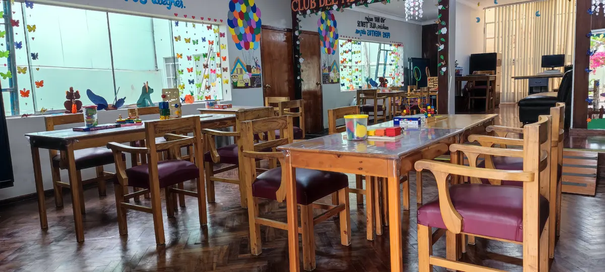 Salón con mesas y materiales de actividades.